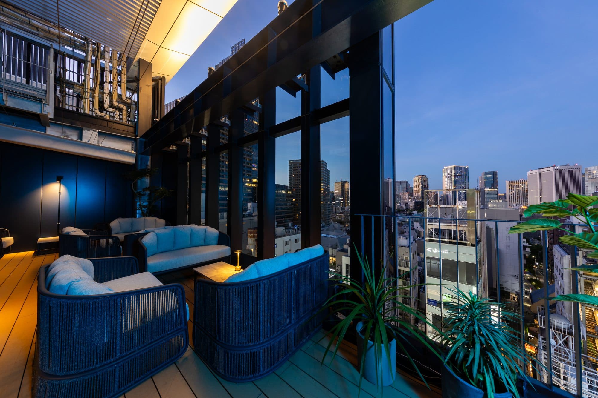 10F Rooftop Terrace。全面ガラスの窓越しに広がる六本木の夜景とソファ席